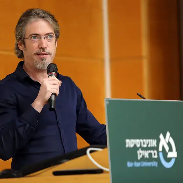 The lecturer stands at the podium and speaks.