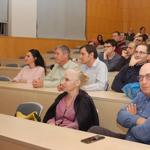 The company from enics labs and other guests sit and listen to the lecturer